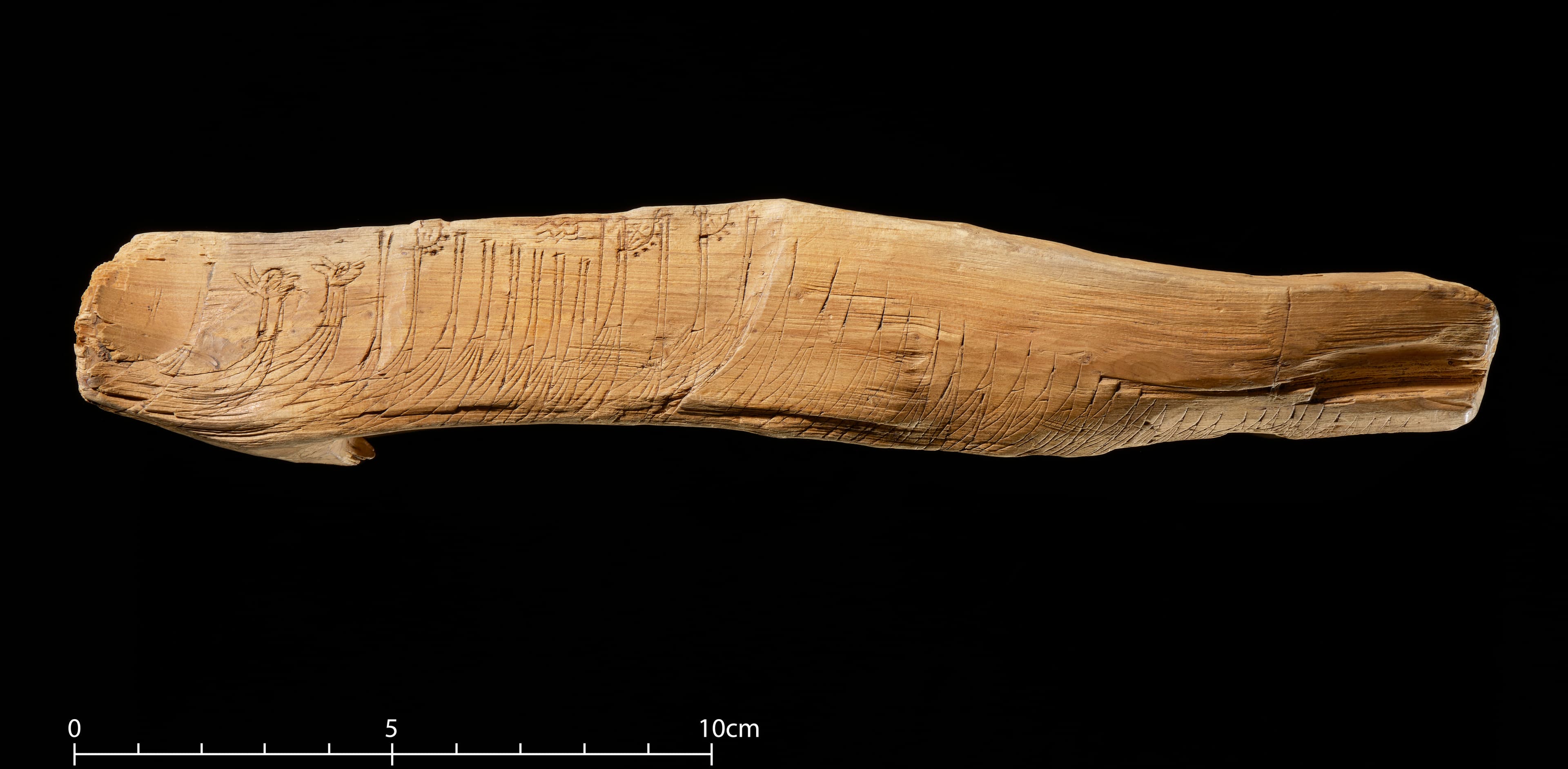 Rune stick of wood incised with a war fleet and an inscription.