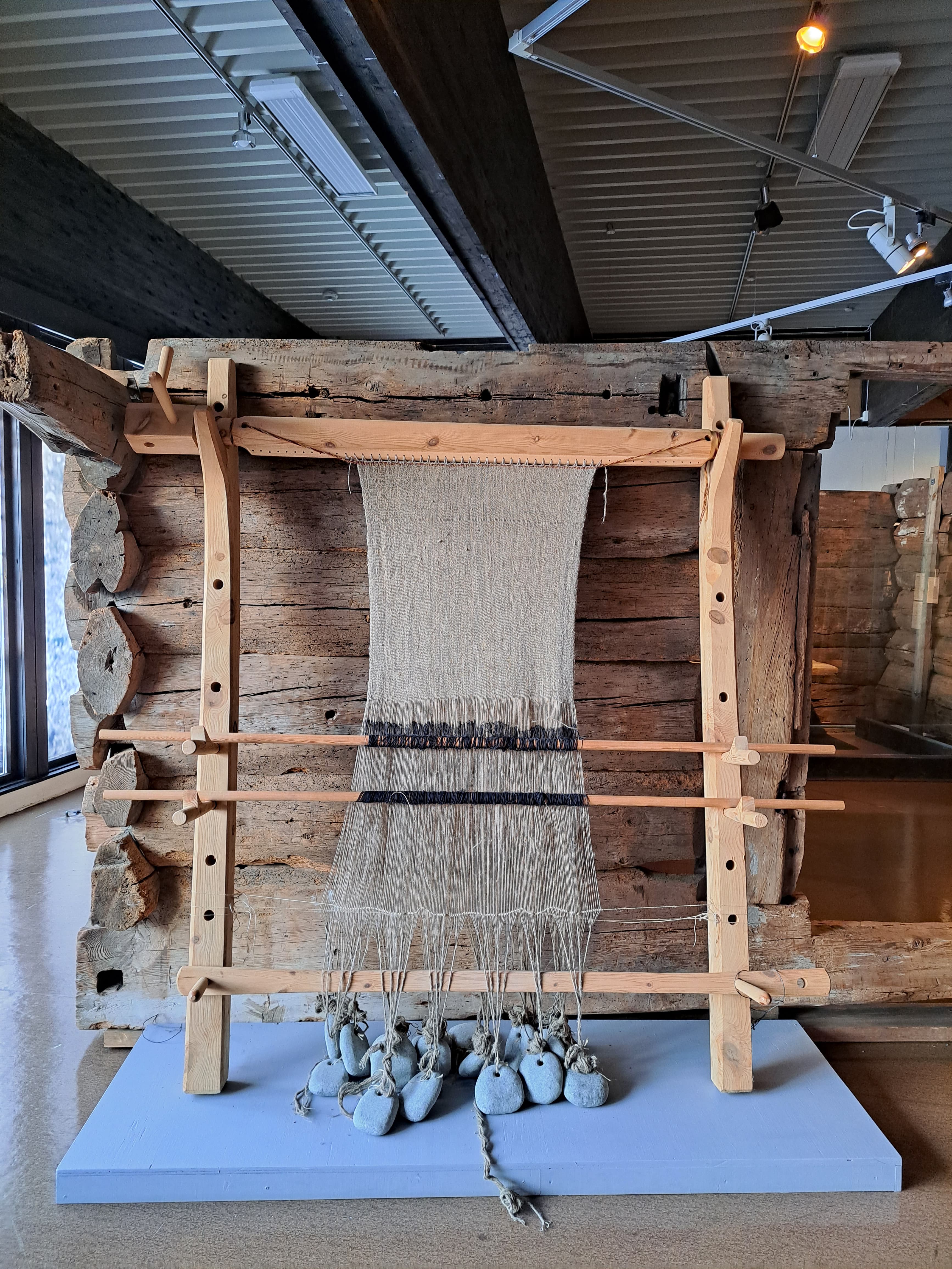 Photo of reconstructed warp-weighted loom with canvas from a museum exhibition.